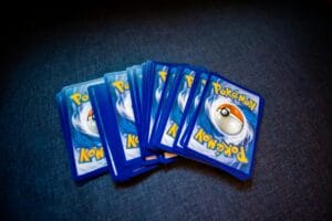A collection of Pokemon trading cards laid out on a dark surface showcasing their distinct back designs